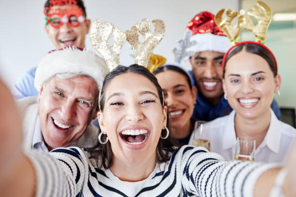 Shot of a group of businesspeople taking a selfie during a Christmas party at work Joining in on the festivities office christmas party stock pictures, royalty-free photos & images