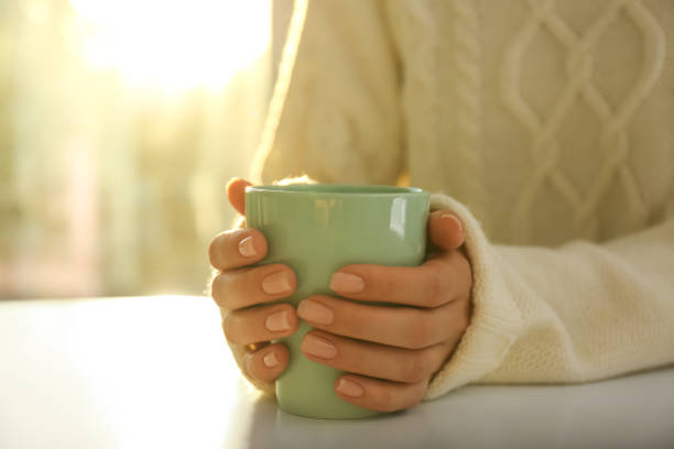 istock Woman holding elegant cup at table indoors, closeup 1383473220