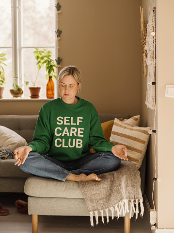 Woman in self care sweater mindfulness concept\nPhoto taken indoors in living room