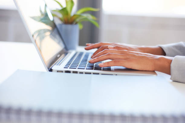 istock A young woman's hands typing on a laptop in the office 1383473362