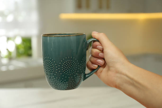 istock Woman holding elegant blue cup in kitchen, closeup 1383473533
