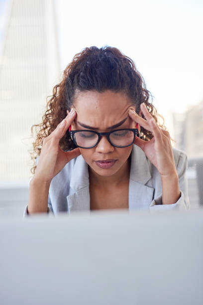istock A young woman sits at her computer screen in city office with a headache 1383474720