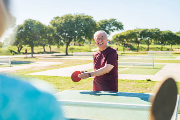 istock Asian american senior man having fun while playing table tennis 1383476375
