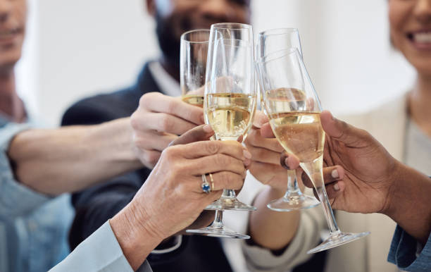 職場でシャンパンで乾杯しながら祝うビジネスマンのグループのクローズアップショット - party business toast champagne ストックフォトと画像