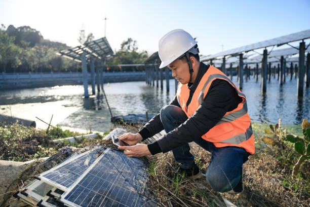 un ingegnere sta esaminando i pannelli solari danneggiati. - green economy foto e immagini stock