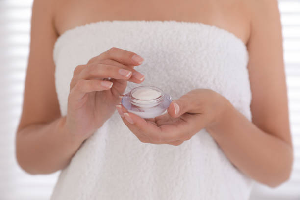 istock Woman holding jar with cream on light background, closeup 1383481699