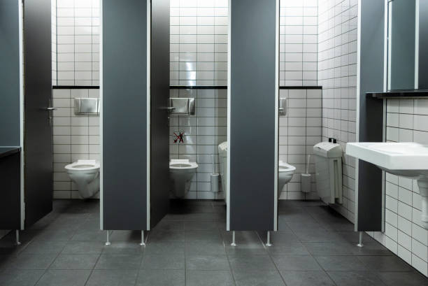 Toilet cubicles with open doors in a public restroom Row of toilet cubicles with open doors in a clean public restroom public restroom stock pictures, royalty-free photos & images
