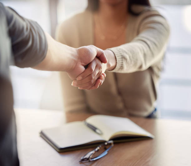 istock Shot of two unrecognizable businesspeople shaking hands at work 1383485379
