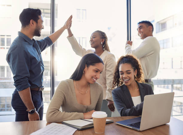 shot of a group of businesspeople celebrating in an office at work - excitement business person ecstatic passion imagens e fotografias de stock