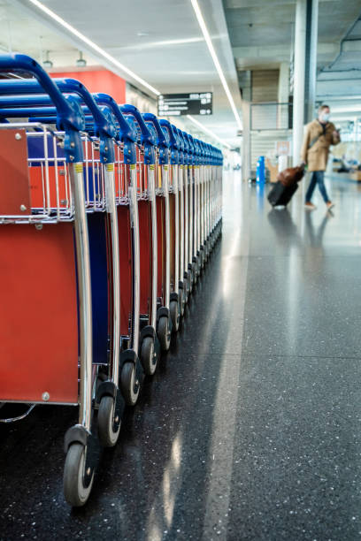 istock Suitcase trollies stacked in a row for airport passengers 1383485569