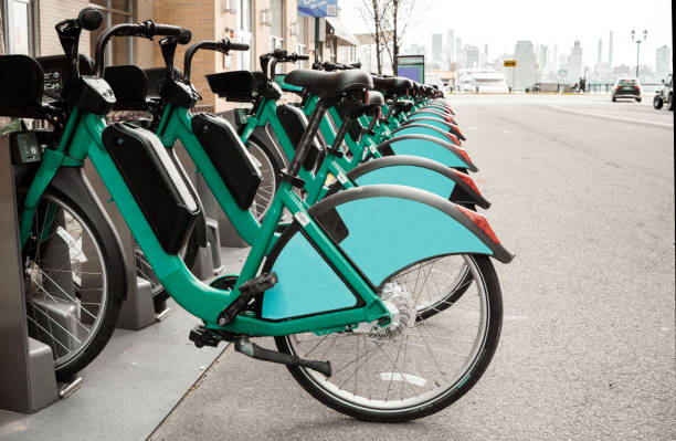 bicicletas eléctricas estacionadas en un estante en una calle de la ciudad - bikeshare fotografías e imágenes de stock