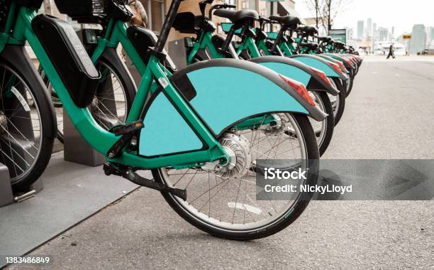 Ebikes Sitting In A Park Station On A City Street Stock Photo - Download Image Now - Sharing Economy, City, Copy Space