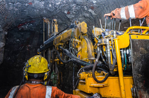 Mining operator on mining machine, underground mine mesh. stock photo