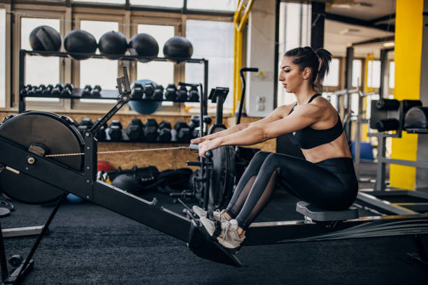 istock Woman exercises on rowing machine 1383489660
