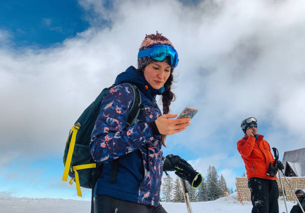 istock women checking her phone while going to the ski track 1383491254