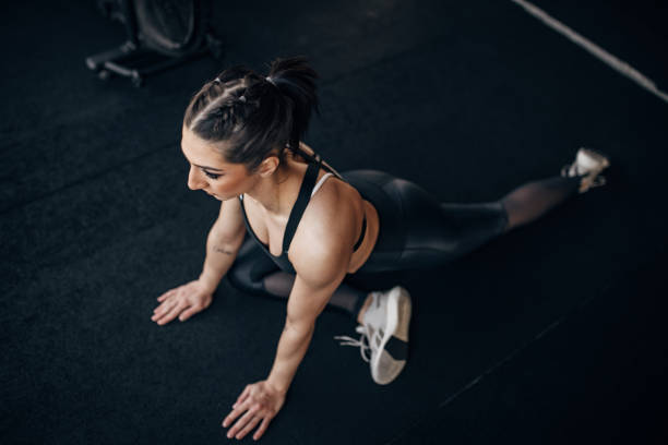istock Young woman exercising in gym 1383491325