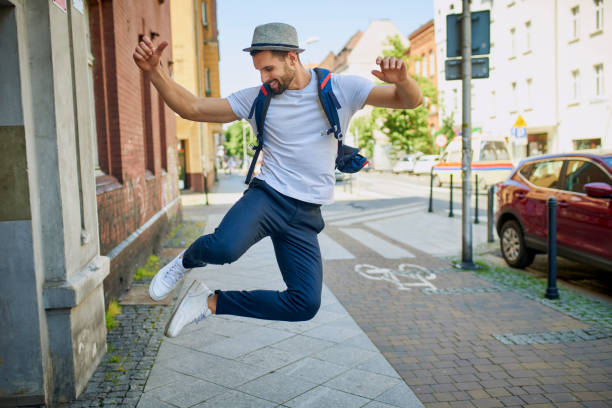 Handsome man dancing jumping on city street