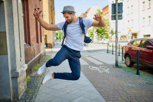 handsome man dancing jumping on city street - hop imagens e fotografias de stock