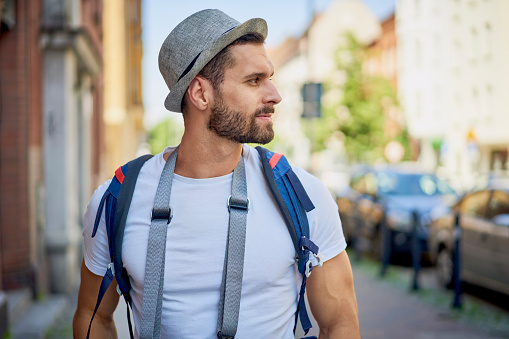 Closeup portrait of young man exploring European city during summer vacations