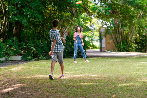 istock Kids playing frisbee in the grass 1383493203