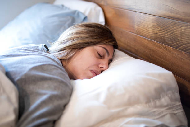 istock Woman sleeping in bed 1383495496