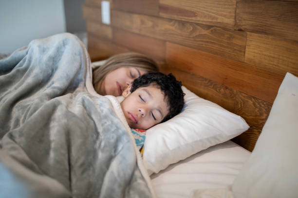 istock Mother and child sleeping in bed 1383495500