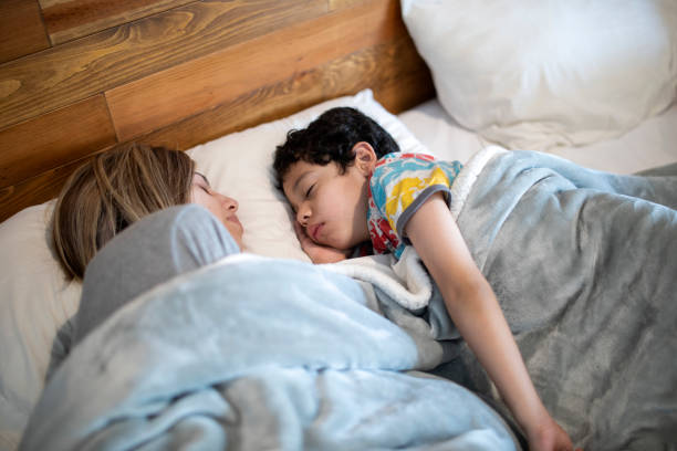 istock Mother and child sleeping in bed 1383495529