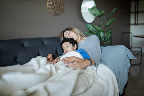 istock Mother and child sleeping on the couch 1383495570