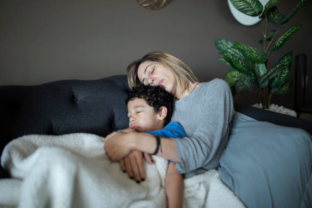 istock Mother and child sleeping on the couch 1383495585