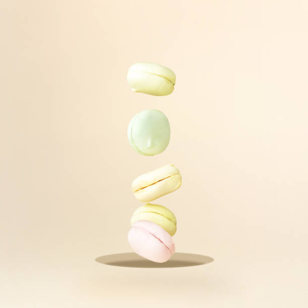 Sweet and colourful marshmallow french macaroons is falling down. Creative and moody minimal concept.