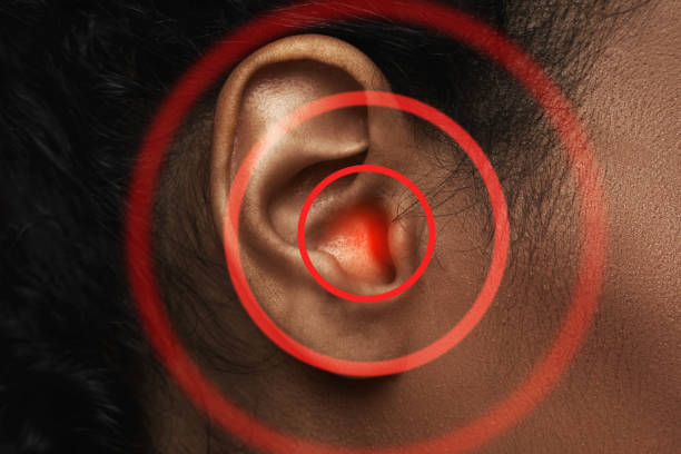 Close-up of black woman's ear with source of pain Close-up of black woman's ear with red source of pain ear drumm stock pictures, royalty-free photos & images