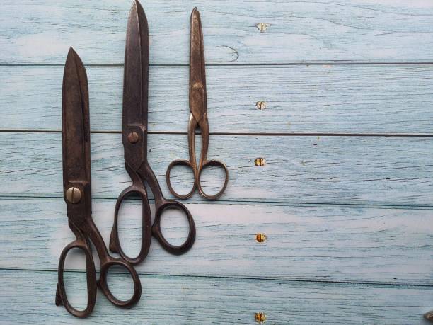Antique scissors on an old wooden table, top view. Space for Text.