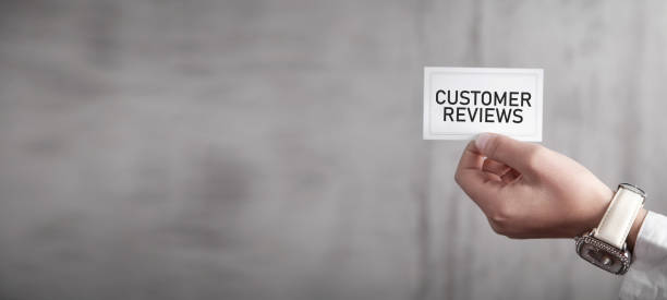 istock Human hand showing Customer Reviews message on business card. 1383501488