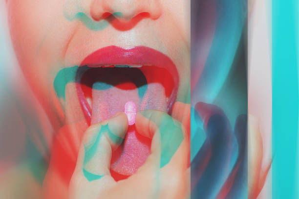 Woman with psychoactive drug pills on her tongue having psychedelic trip with hallucinations stock photo