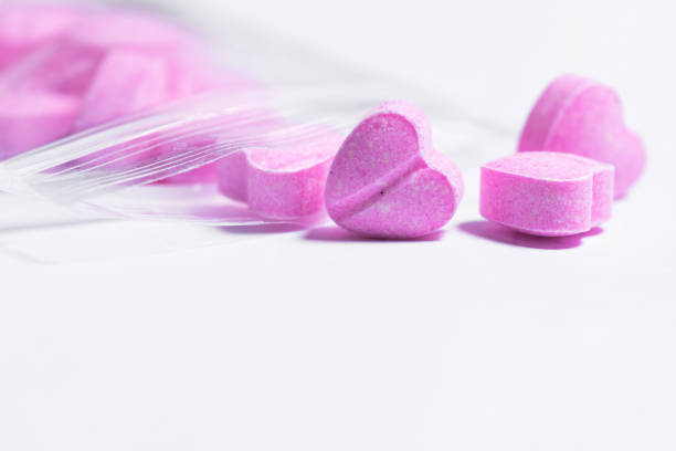 bolsa ziplock y pastillas rosadas en forma de corazón. - pink pill fotografías e imágenes de stock