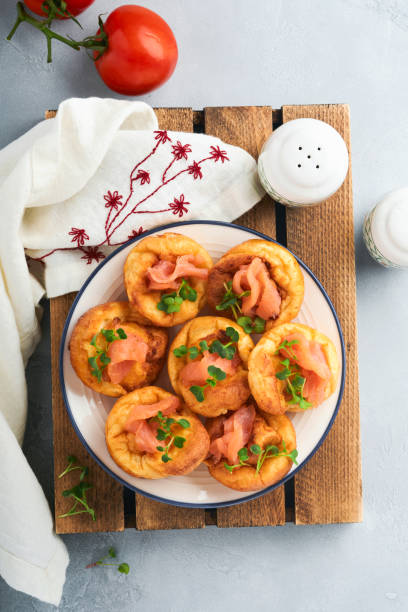istock Yorkshire pudding. Traditional English Yorkshire pudding with salmon and radish microgreens side dish on white plate and light grey background table. Top view. 1383505089