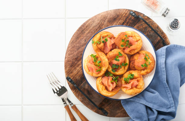 istock Yorkshire pudding. Traditional English Yorkshire pudding with salmon and radish microgreens side dish on white plate and light grey background table. Top view. 1383505190