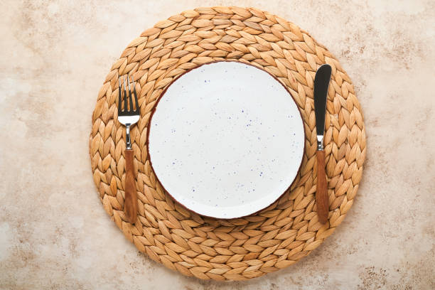 istock Vintage zero waste silverware. Rustic vintage set of white plate, wooden spoon and fork on napkin for dishes from water hyacinth on light gray concrete background. Empty dishes. Top view. Mock up. 1383505528