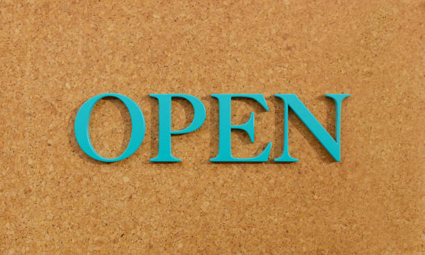 istock Open. Word in capital letter against a brown cork-board. 1383506742