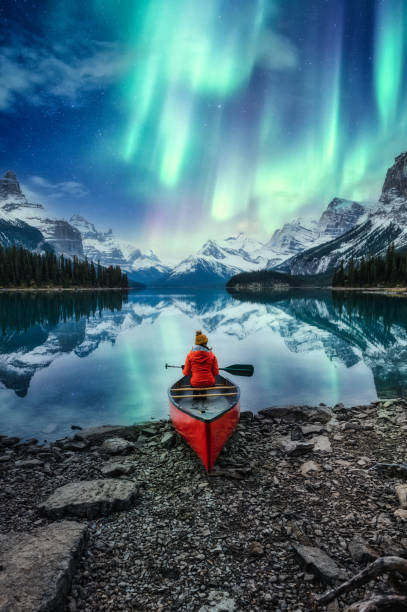 hermosa aurora boreal sobre la isla del espíritu con una viajera en canoa en el parque nacional jasper - recreational boat fotos fotografías e imágenes de stock