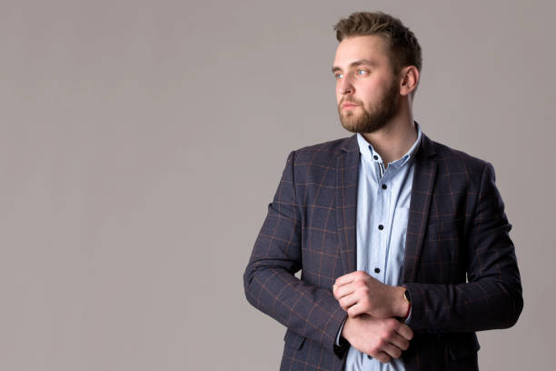 istock Handsome bearded man in a jacket and shirt on a gray background. 1383510531
