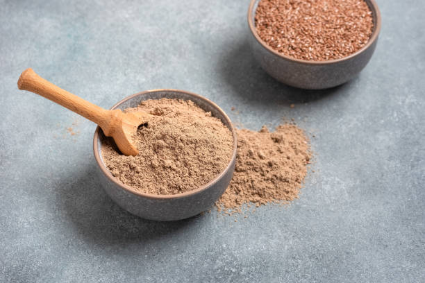 istock Flax flour. Flaxseed flour in a bowl on a gray concrete grunge background. Side view, selective focus. 1383511385