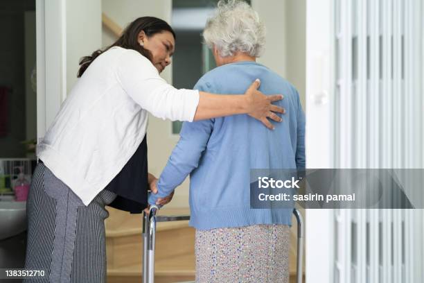 Caregiver Help Asian Or Elderly Old Woman Walk With Walker Support Up The Stairs In Home Stock Photo - Download Image Now