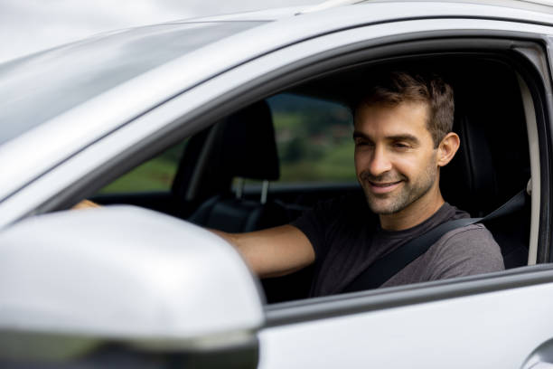 istock Man driving a car and looking at the side-view mirror 1383516979
