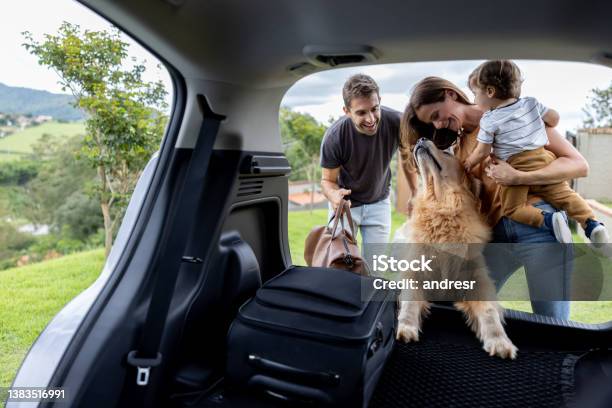 Happy Family Loading Bags In The Car And Going On A Road Trip Stock Photo - Download Image Now
