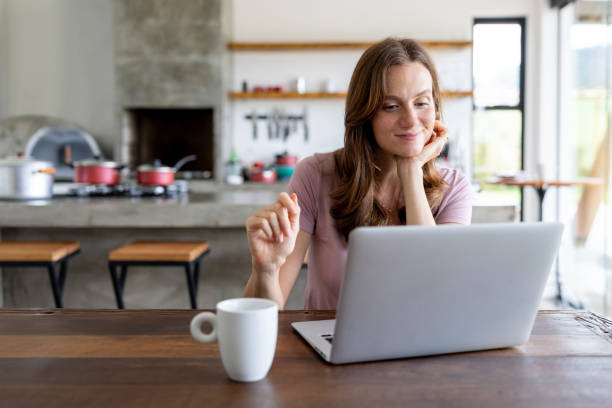 istock Happy woman working at home on her laptop 1383517040