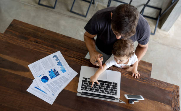 Father working at home but baby interrupting his session