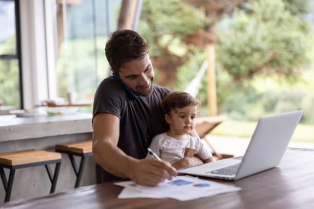 istock Busy father working at home while taking care of his son 1383517059