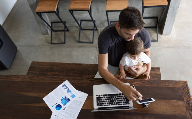 istock Single father working at home and entertaining his son with online videos 1383517064