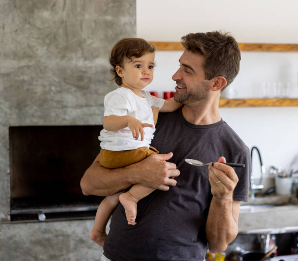 istock Happy father feeding his baby at home 1383517069